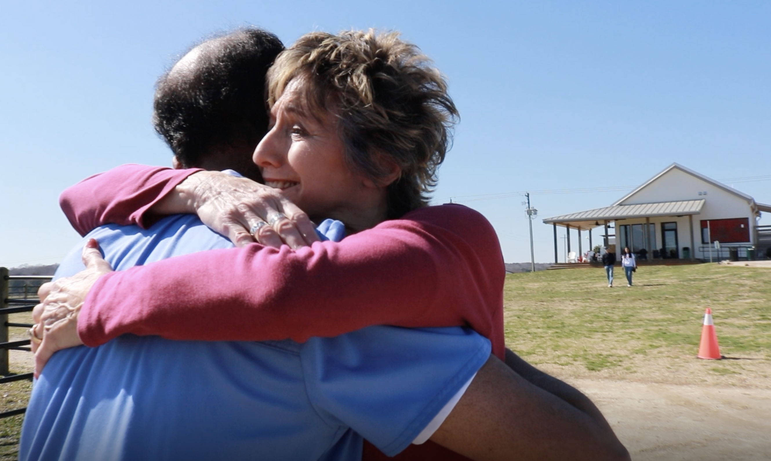Co-founder Neal hugs smiling community member with rural background