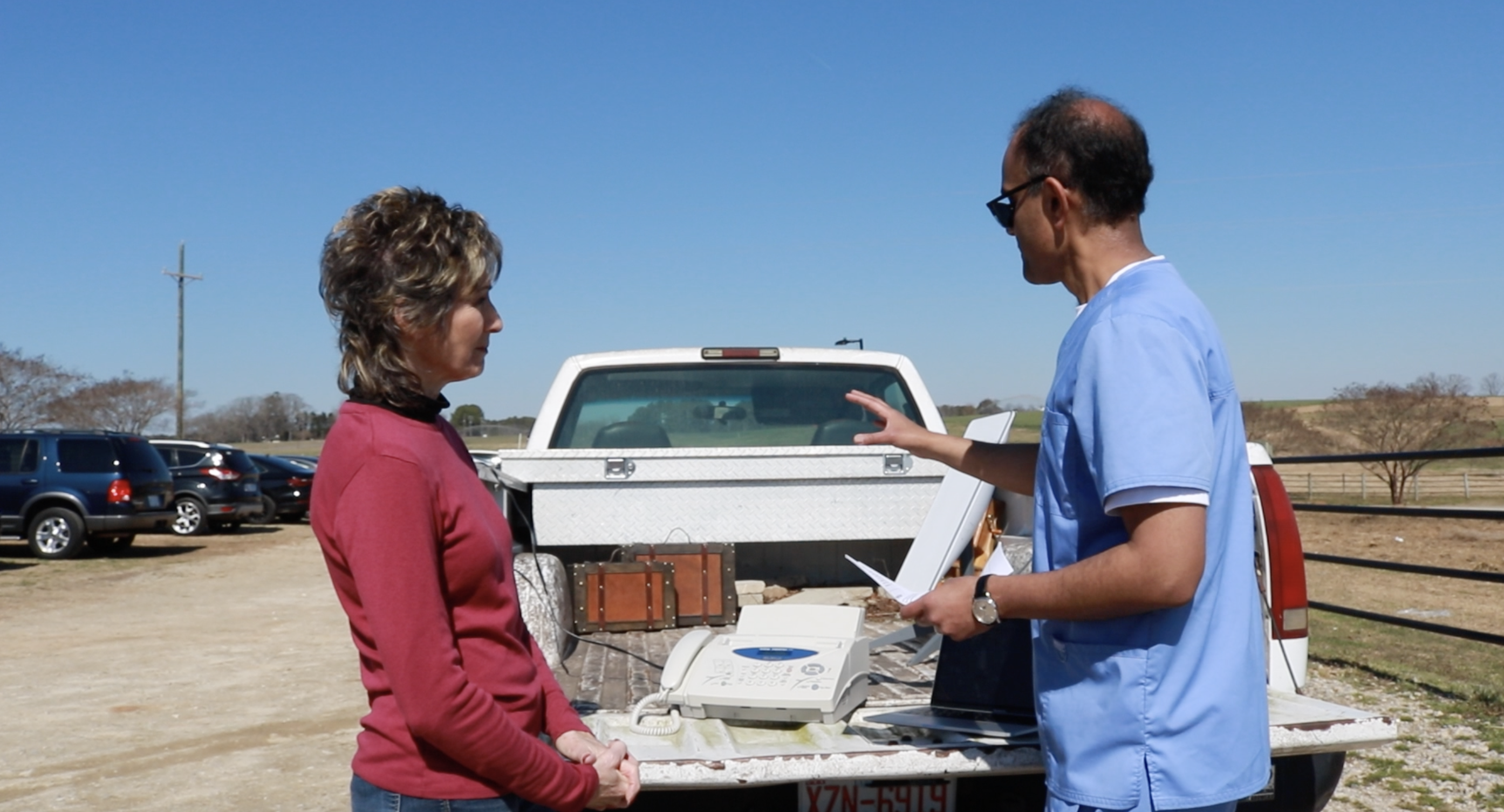 Neal helping community member in front of mobile clinic